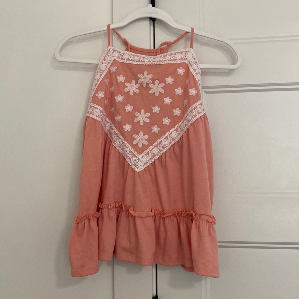 Women’s pink and white tank top with adjustable straps and flows at the bottom